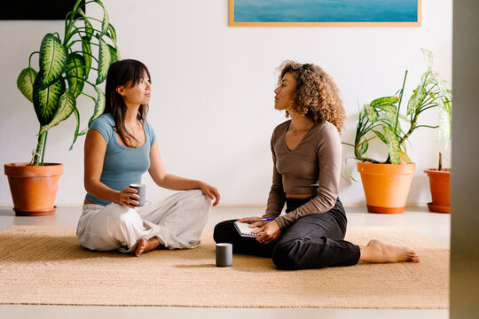 Diverse women enjoy a peaceful moment jotting down notes in a journal