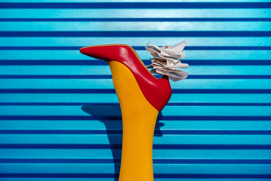 Red High Heel with Receipts Against Blue Metal Background