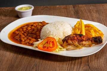 grill roasted chichen serve with rice an pinto beans french fries and salad 