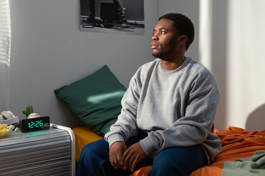 Pensive student relaxing in dorm room after school day