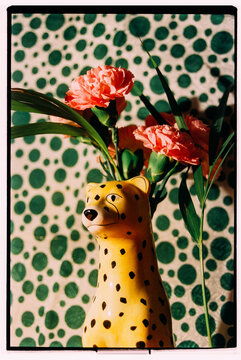 Vibrant leopard figurine with flowers on dotted backdrop