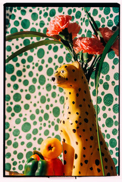 Brightly colored cheetah figurine with flowers and fruits on display
