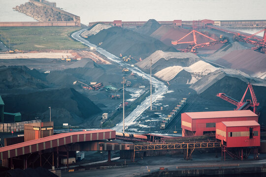 Coal terminal managing large piles of black anthracite near the sea