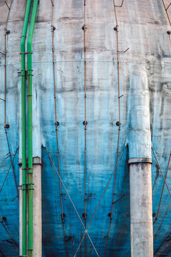 Green pipes running along blue painted concrete industrial