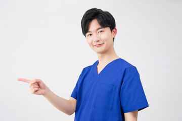 医者・看護師・歯科医師・介護士　左側を指差す男性　　白背景