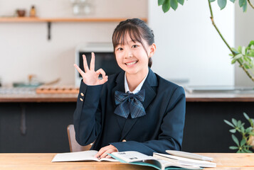 家で勉強する制服姿の小学生,中学生,高校生の女の子
