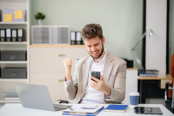 Fototapeta premium Confident businessman working on finance analysis with a tablet and laptop at office desk.