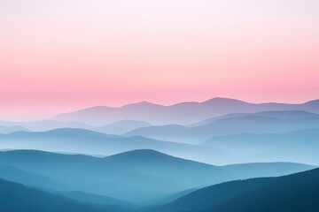 Serene mountain landscape with layers of blue and pink hues at sunrise.