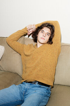 Non-Binary Person Posing on Couch in a Sweater