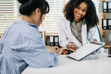 Obraz premium Asia female doctor using clipboard is delivering great news talk discuss results or symptoms with female patient