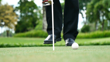 Businessman playing Golf ball practice hit swing on tee in golf club outdoor green field with...