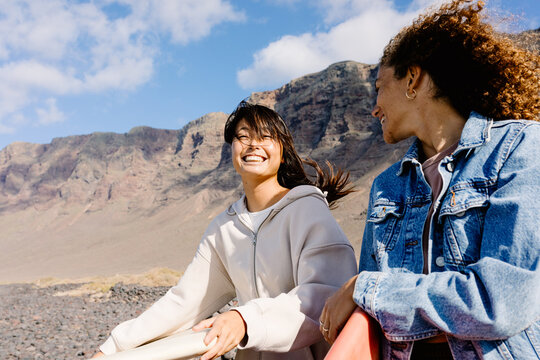 A mid-range shot with copy space of surfing friends chatting outdoors