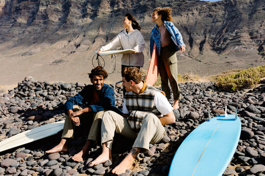 Diverse surfer friends enjoying quality time together outdoors