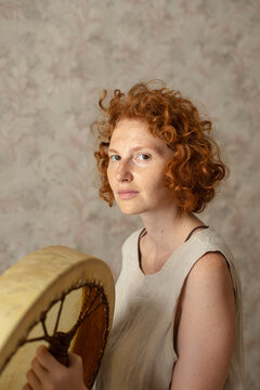 
portrait of a red-haired woman with a tambourine