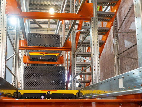 Automated warehouse rack. Platform for lifting loads is built into warehouse furniture. Technologies for storage automation. Automated warehouse equipment. Multi-tier racking with automated platform