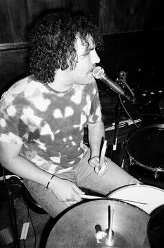Young Man Plays the Drums and Sings at a Concert