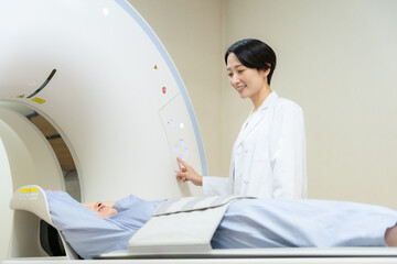 病院でCT検査を受ける女性　撮影協力 学校法人電波学園 東京電子専門学校