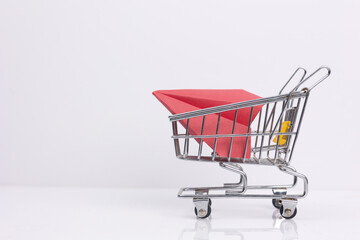 Shopping cart with a red paper airplane symbolizing online purchases, delivery and incrasing sale