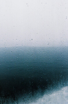 Abstract texture of raindrops on fogged up ferry boat window