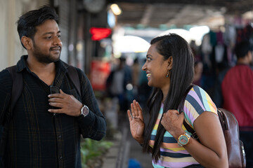 Friends are standing in a busy street and making happy conversation