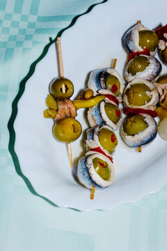 plate with some spanish banderillas, skewers with pickles