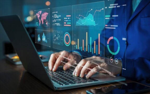 Person analyzing data on a laptop with digital graphs and charts in a dimly lit setting.
