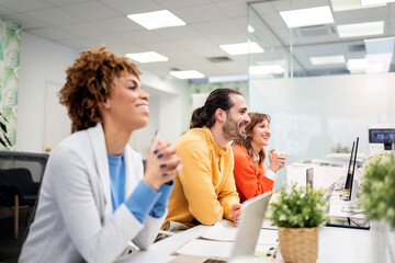 Smiling business people attending a conference in modern office