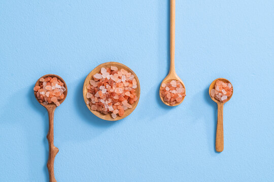 Himalayan Pink Salt In Wooden Spoons On A Blue Background