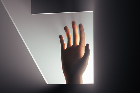 Hand reaching out for help in soft back light setting