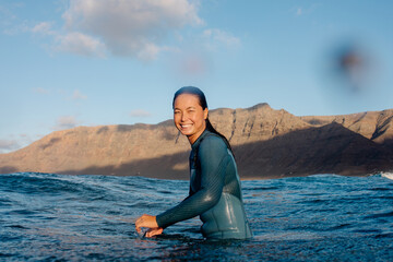 A mid-frame aquatic portrait of an Asian surfer enjoying a practice