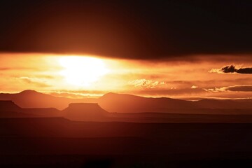 Obraz premium Dramatic Sunset Over Utah Canyonlands with Silhouetted Mesas