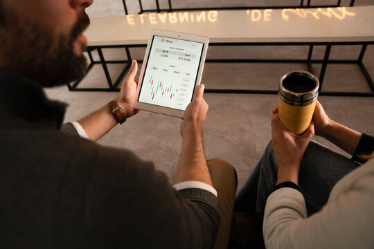 Digital tablet showing cryptocurrency chart during casual meetup
