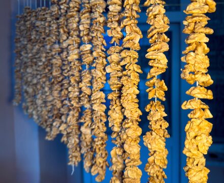 Close-Up of Strung Walnut Kernels Drying in a Bright Indoor Setting