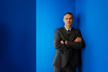 Confident man looking at camera against blue background
