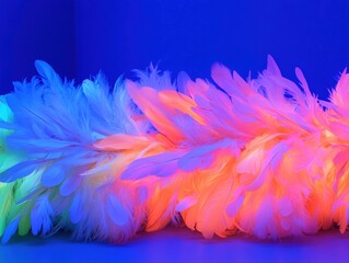 Obraz premium Beautiful feather resting on a vibrant blue background surrounded by neon strands creating an artistic and dreamy atmosphere