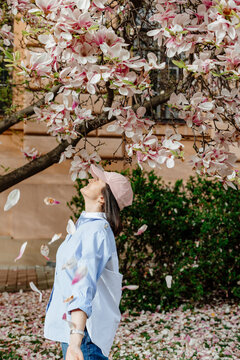 Happy girl in spring near the magnolia flowers