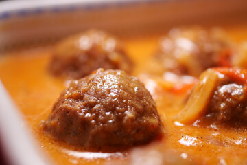 Meatballs simmering in rich sauce at a cozy kitchen