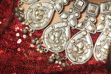 Stunning jewelry detail on a sparkling red sequined fabric