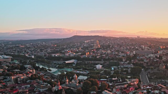 Aerial Beautiful view on Tbilisi, Georgia. Sunrise shot, beautiful cinematic city view. Cityscape. beautiful sky and buildings, Orthodox Churches, old buildings and Mtkvari River.