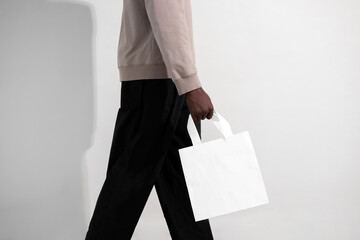 Man walking with blank white paper bag mockup