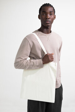 Stylish Man Holding a White Tote Bag Mockup
