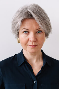 Portrait of a woman with short gray hair and blue eyes