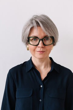 Woman with stylish glasses and short gray hair