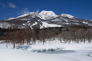 晴の冬 一面雪景色の妙高高原 凍結したいもり池と雪をいただく妙高山