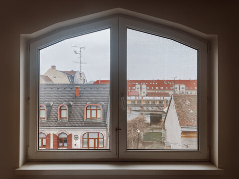 Fototapeta View from a window with houses and roofs