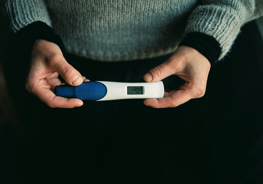 a woman holding a positive pregnancy test