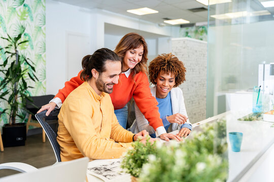 Business team collaborating on computer project in modern office