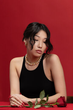 Sensual female portrait with a red rose