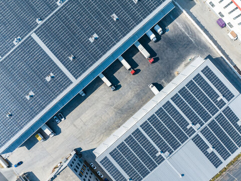 Aerial View of Factory with Solar Panels and Transport Trucks