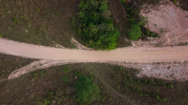 Wide aerial shot of a dirt road surrounded by greenery in Serra da Canastra, Brazil